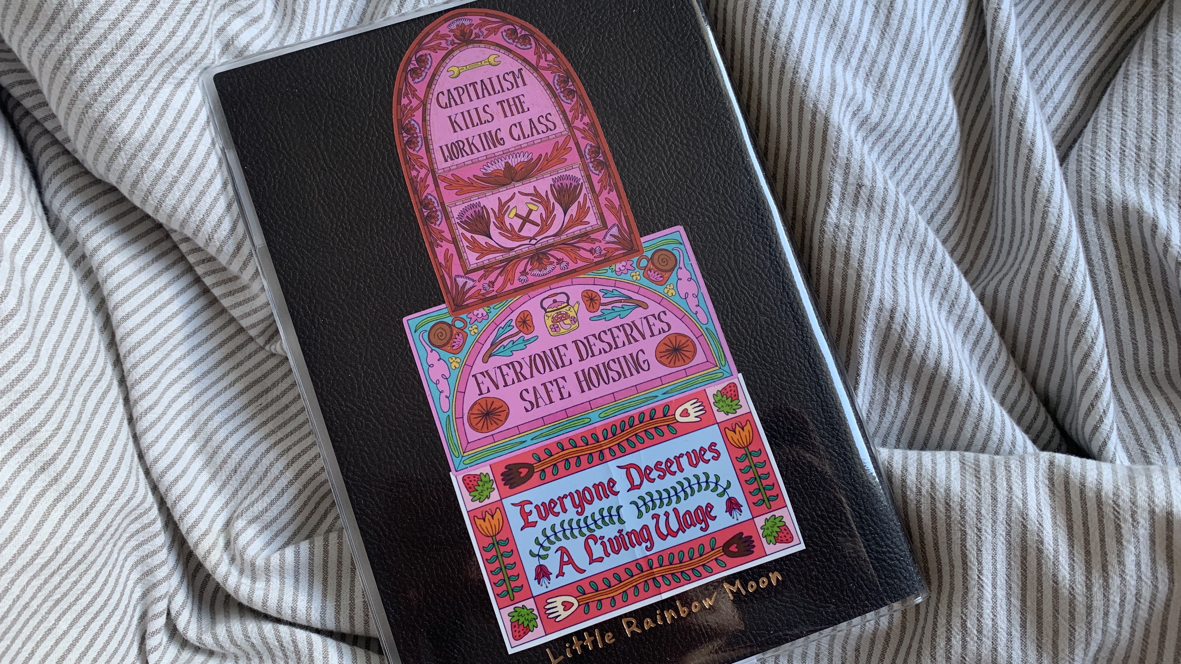 Three stickers. "Capitalism kills the working class", "everyone deserves safe housing", "everyone deserves a living wage".